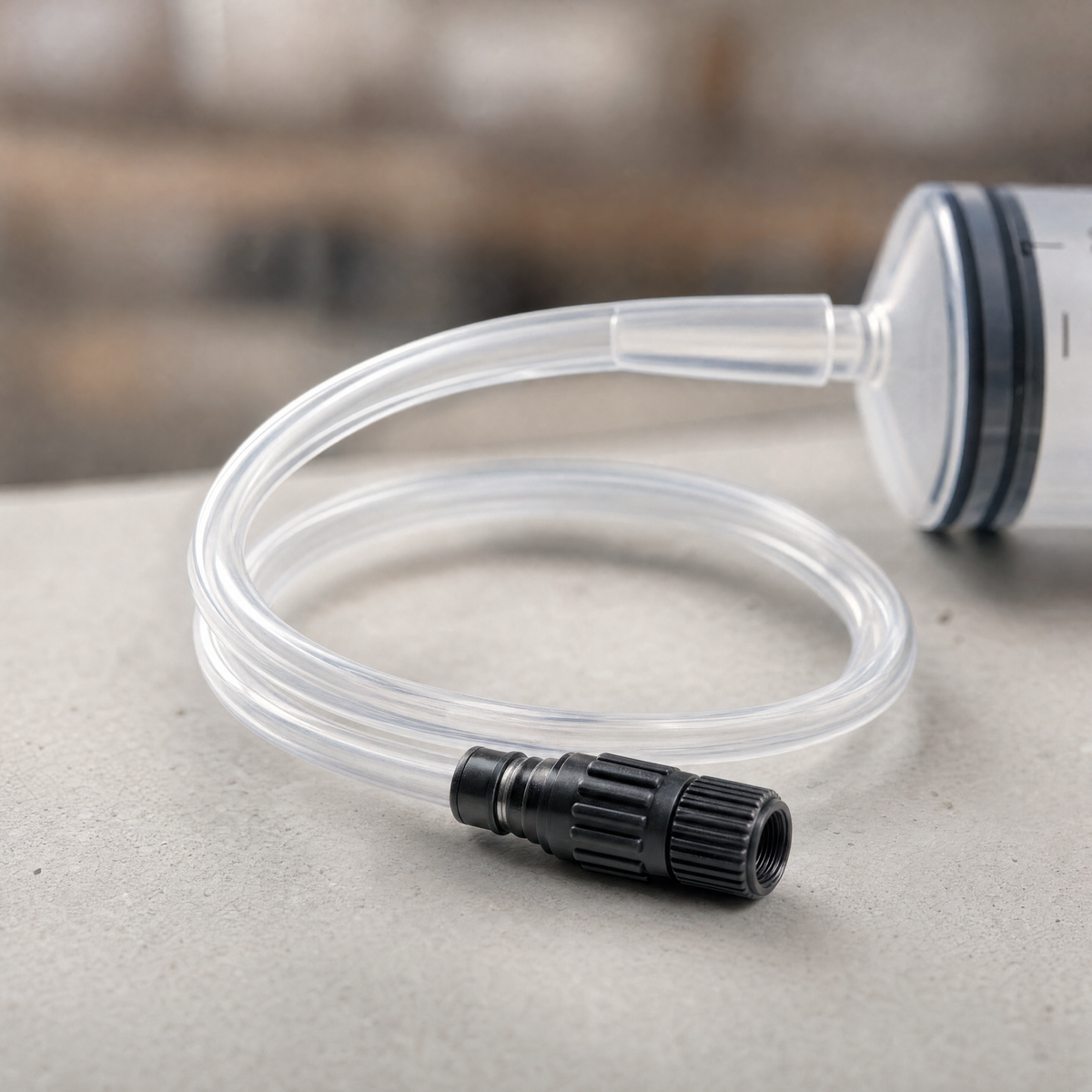 The Magic Milk injector's clear flexible tube and threaded valve adapter